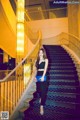 A woman standing on a set of stairs in a building.