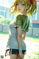 A girl in a green shirt and black shorts standing in a field.