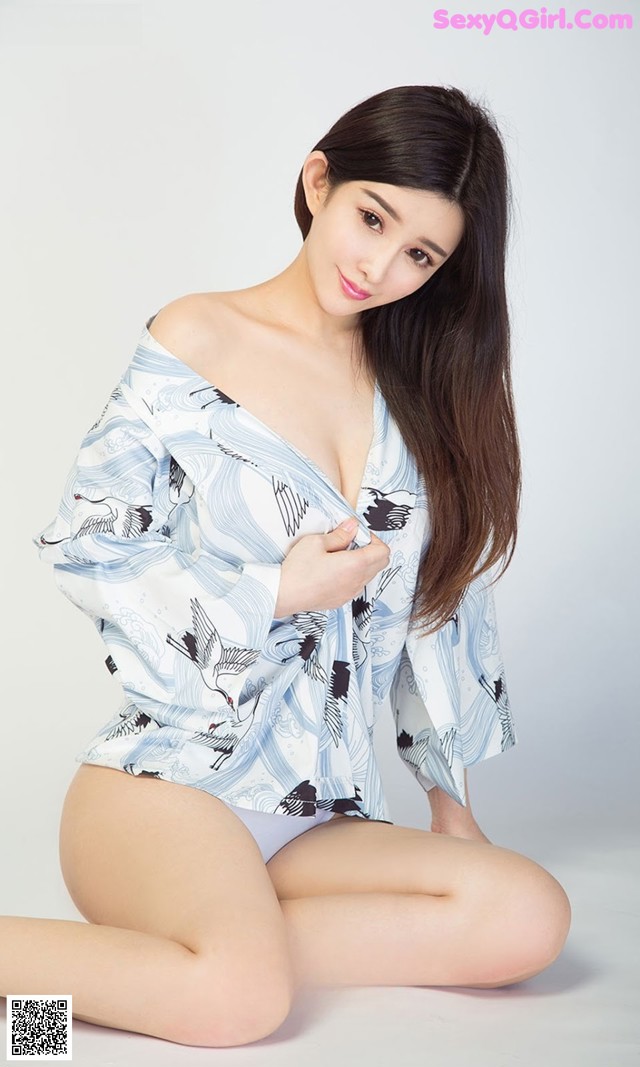 A woman in a blue and white shirt is posing for a picture.