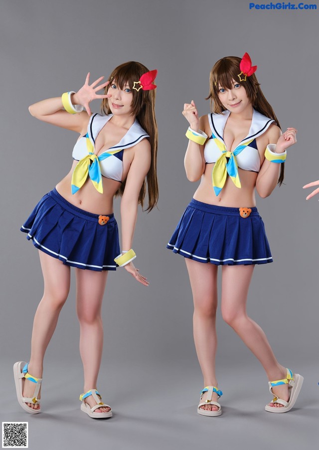 Two young women dressed in sailor outfits posing for a picture.