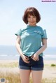 A woman standing on a beach next to the ocean.