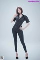 A woman in a black shirt and black pants posing for a picture.